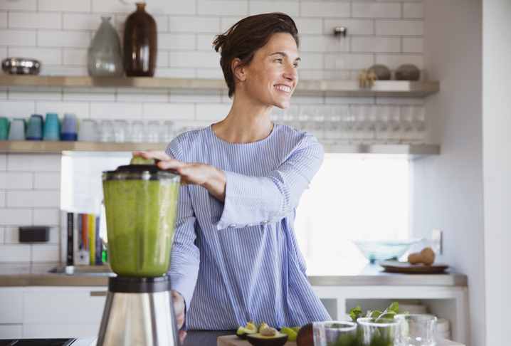 Woman making green smoothie