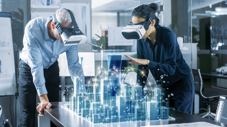 Male and Female Architects Wearing  Augmented Reality Headsets Work with 3D City Model. High Tech Office Professional People Use Virtual Reality Modeling Software Application.